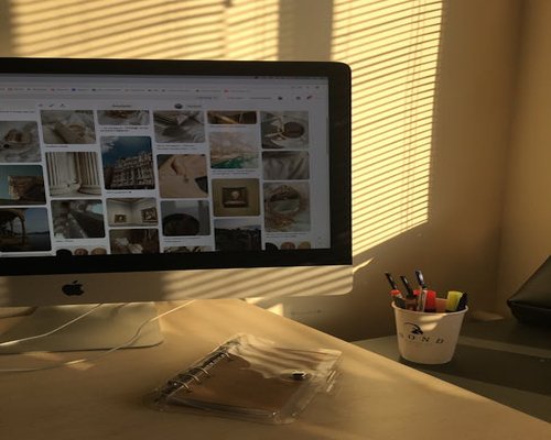 window blinds filtering sunlight away from a computer screen